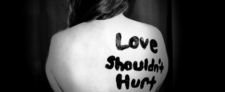 love shouldn't hurt printed on woman's back